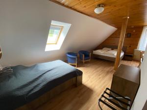 ein Schlafzimmer mit einem Bett und zwei blauen Stühlen in der Unterkunft Encijan Apartments in Log pod Mangartom