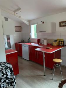 a kitchen with red cabinets and a red counter top at Gîte calme et cosy d' Eole in Cornillon-Confoux