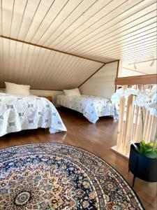 um quarto com duas camas e um tapete em Himos Mökki superior - Chalet Cottage superior ski-in-ski-out em Jämsä