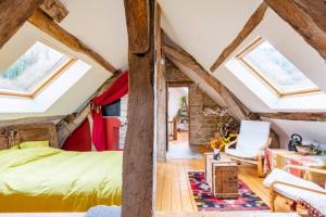 een slaapkamer met een groen bed en dakramen bij Maison du Rostaing in Passenans