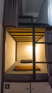 Sunshot Hostel في ليغِيان: سرير بطابقين علوي مع بطانية صفراء عليه