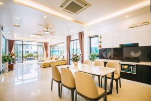 - une cuisine et une salle à manger avec une table et des chaises dans l'établissement Villa FLC Sầm Sơn, à Sầm Sơn