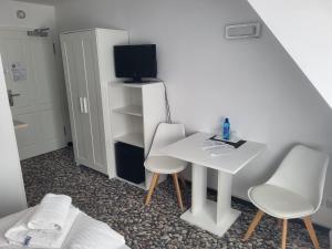 Habitación pequeña con mesa blanca y 2 sillas en Die Remise Marengo en Stolpe auf Usedom