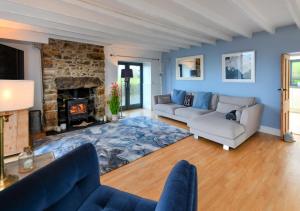a living room with two couches and a fireplace at 1 Fron Dirion in Llanbedrog