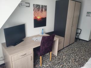 Zimmer mit einem Schreibtisch, einem TV und einem Schreibtisch. in der Unterkunft Die Remise Bayard RE-12 in Stolpe auf Usedom