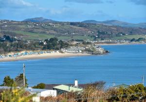 a view of a beach with a house and the ocean at The Tack Room in Abersoch