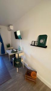 Zimmer mit einem Schreibtisch und einem Tisch mit einer Uhr an der Wand in der Unterkunft Joli studio Camargue Lou Rouge Arles in Arles