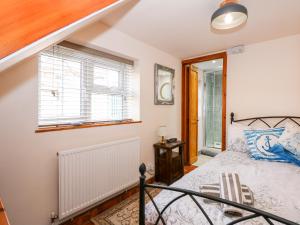 a bedroom with a bed and a window at Beck Cottage in Sheringham