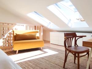 a attic bedroom with a yellow chair and a desk at Beach & City - Trafaria in Trafaria