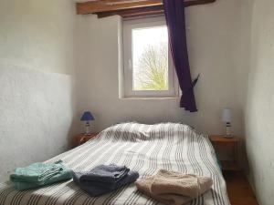 een bed met twee handdoeken in een kamer met een raam bij Gîtes La Vicomterie in Ver