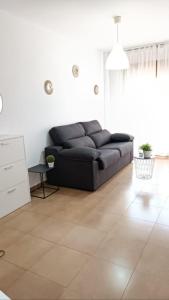 uma sala de estar com um sofá preto num quarto em Mar Menor em San Pedro del Pinatar