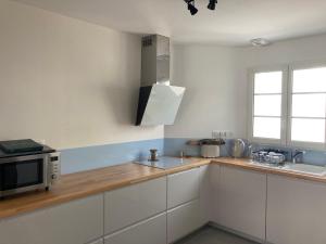 a kitchen with white cabinets and a microwave at Villa St. Georges in La Rochelle