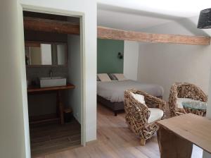 een slaapkamer met een bed, een wastafel en een tafel bij Gîte Oust Au LIt in Saint-Vincent-sur-Oust
