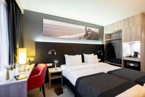 a hotel room with a bed and a desk at Mercure Oostende in Ostend