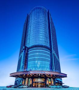 un edificio de cristal alto con un cartel. en Days Hotel & Suites China Town - Metro Line 2 - Nearby Wuyi Square ,Orange Island,Hunan Museum, en Changsha