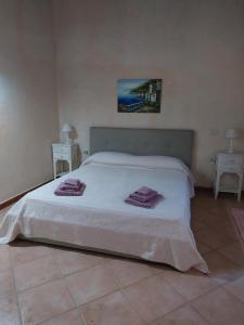 a bedroom with a white bed with towels on it at Affitta camere Matta-Chiodino in Arzachena