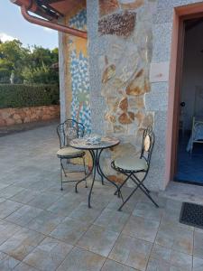 a table and two chairs on a patio at Affitta camere Matta-Chiodino in Arzachena