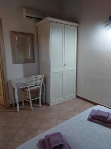 a bedroom with a white cabinet and a table at Affitta camere Matta-Chiodino in Arzachena