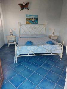 a bedroom with a large bed with blue tile floors at Affitta camere Matta-Chiodino in Arzachena