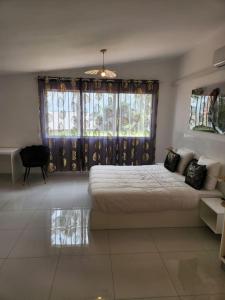 - une chambre avec un lit et une grande fenêtre dans l'établissement Hello-Guyane, Marina 6, Suite Prestige 5 étoiles, à Saint-Laurent du Maroni