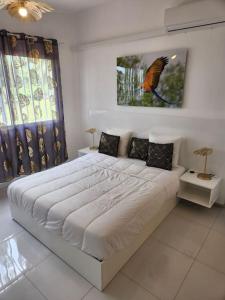 - une chambre dotée d'un grand lit et d'une peinture ornithologique sur le mur dans l'établissement Hello-Guyane, Marina 6, Suite Prestige 5 étoiles, à Saint-Laurent du Maroni