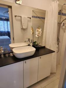 La salle de bains blanche est pourvue d'un lavabo et d'une douche. dans l'établissement Hello-Guyane, Marina 6, Suite Prestige 5 étoiles, à Saint-Laurent du Maroni
