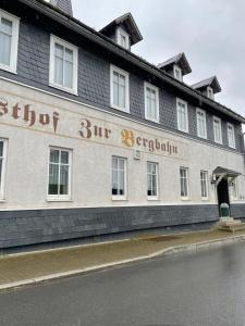 a building with a sign on the side of it at Pension zur Bergbahn in Lichtenhain