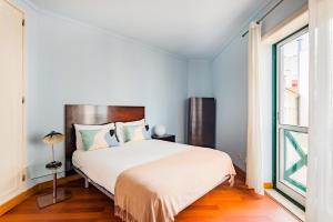 um quarto com uma cama grande e uma janela em São Bento Classic em Lisboa