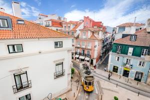 um autocarro amarelo a descer uma rua da cidade com edifícios em São Bento Classic em Lisboa