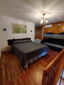 1 dormitorio con 1 cama y suelo de madera en Hameau Gubioche, casa vacanze, en Chambave