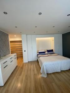 sypialnia z białym łóżkiem i białą komodą w obiekcie Apartment Ariella w Jurmale
