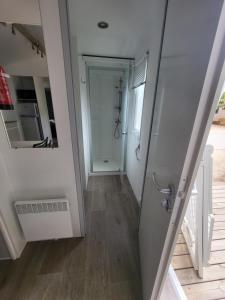 un pasillo con una puerta que conduce a un baño en Mobil-home (Clim)- Camping Narbonne-Plage 4* - 019, en Narbonne-Plage