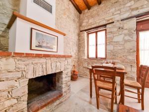 a stone room with a table and a fireplace at Aphrodite's Pool Retreat in Skarinou