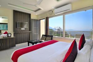 a bedroom with a large bed and a large window at LA Riqueza Bliss Valley Mall Road - Near to Mcleodganj in Dharamshala
