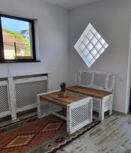 um quarto com dois bancos e uma mesa e uma janela em Casa Albinuța em Călimăneşti