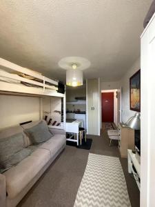 salon z kanapą i łóżkiem piętrowym w obiekcie Studio avec Clim, Parking et Balcon - 3 personnes w mieście Bormes-les-Mimosas