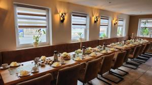 a long table in a room with chairs and food at Zum Obstler - Gaststätte und Pension in Gera