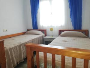 twee bedden in een kamer met een raam bij Mimosa LOCDENIA in Els Poblets