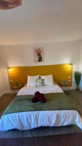 una camera con un grande letto con testiera gialla di Joli Appartement 27m2 Oasis Provençale en village vacances en Camargue a Arles