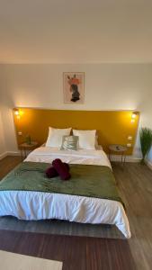 a bedroom with a large bed with a yellow headboard at Joli Appartement 27m2 Oasis Provençale en village vacances en Camargue in Arles