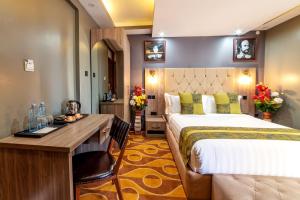 um quarto de hotel com uma cama e uma secretária em Afro Park Hotel em Kampala