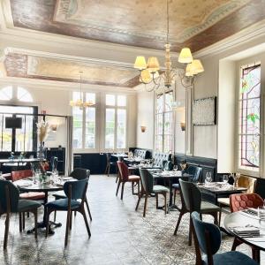 - une salle à manger avec des tables, des chaises et des fenêtres dans l'établissement Logis Le Grand Hotel, à Château-du-Loir