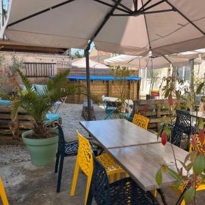 een patio met een tafel en stoelen en een parasol bij Logis Le Grand Hotel in Château-du-Loir