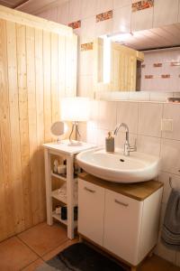 ein Badezimmer mit einem Waschbecken und einem Tisch mit einer Lampe in der Unterkunft Apartment DaVinci - Sauna, Kamin, Garten, E-Bikes in Olpe