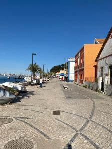 eine Straße neben dem Wasser mit Booten darauf in der Unterkunft Beach & City - Trafaria in Trafaria