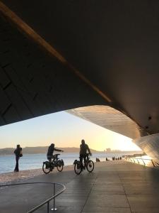grupa ludzi jeżdżących rowerami na plaży w obiekcie Beach & City - Trafaria w mieście Trafaria