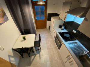 una pequeña cocina con mesa blanca, mesa y sillas en Waren Appartements en Waren
