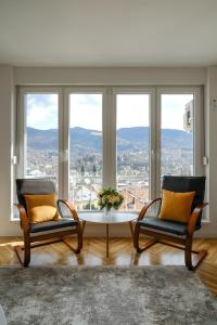 two chairs and a table in front of a window at Apartment Skopljak + free garage in Sarajevo