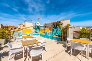 un balcón con mesas y sillas y un mural en Can Rubi - Turismo de Interior, en Palma de Mallorca