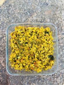 a plastic container filled with yellow food on a table at Chandera Kothi in Orchha